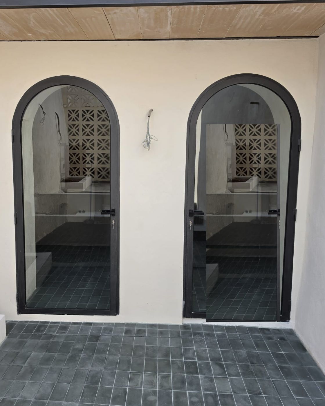 Carpintería exterior de aluminio con arco de medio punto y pavimento de gres en una reforma en Sineu